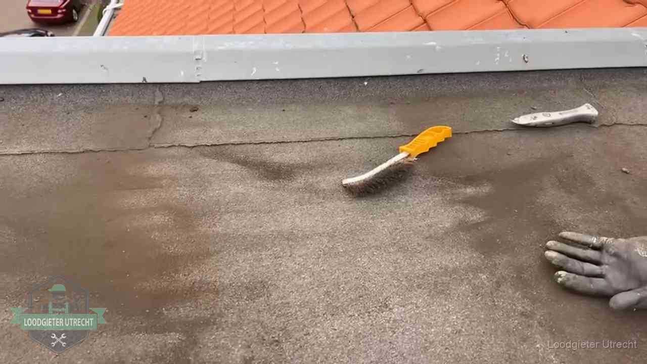 Dakdekker bereidt een bitumen plat dak voor op reparatie bij de daktrim in Utrecht
