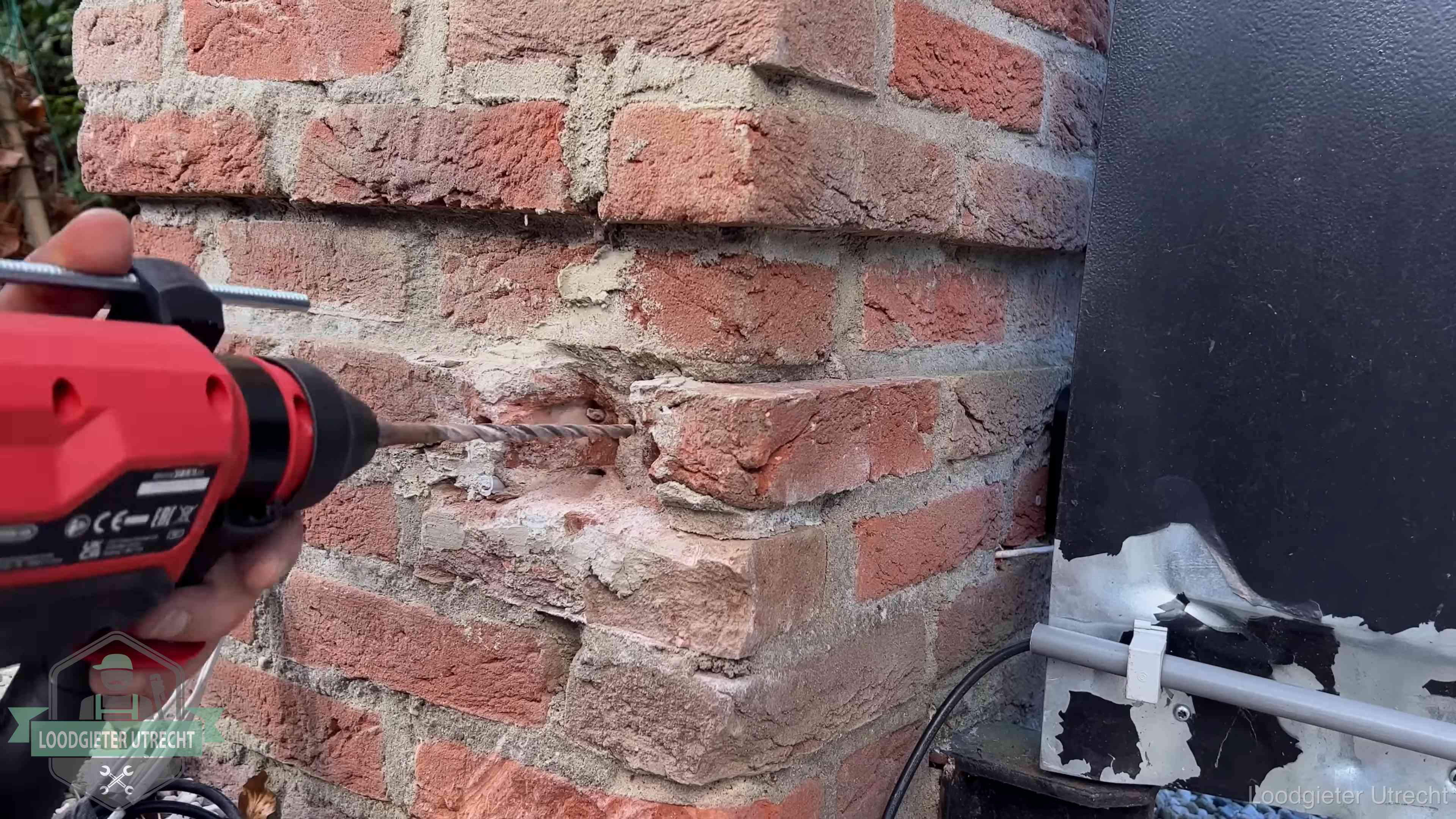 Vakman boort in de buitenmuur van een woning in de regio Utrecht