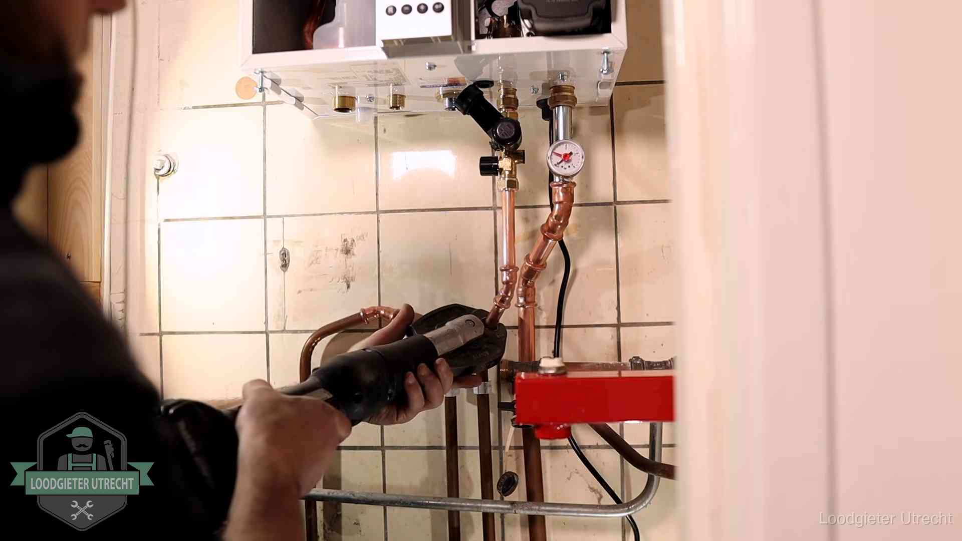 Cv-ketel onderhoud in Utrecht Monteur werkt aan de leidingen onder een cv-ketel in Utrecht