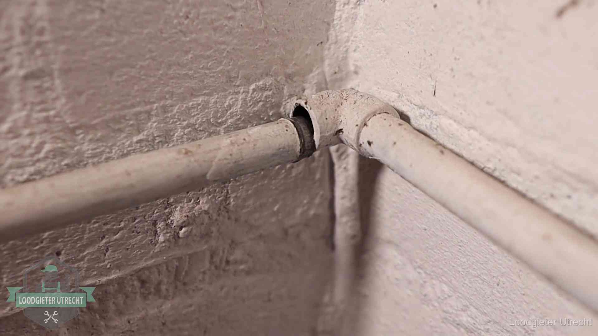 Oude waterleidingen en verborgen lekkage in Utrecht Oude geverfde waterleiding met een losliggende fitting in een woning in Utrecht