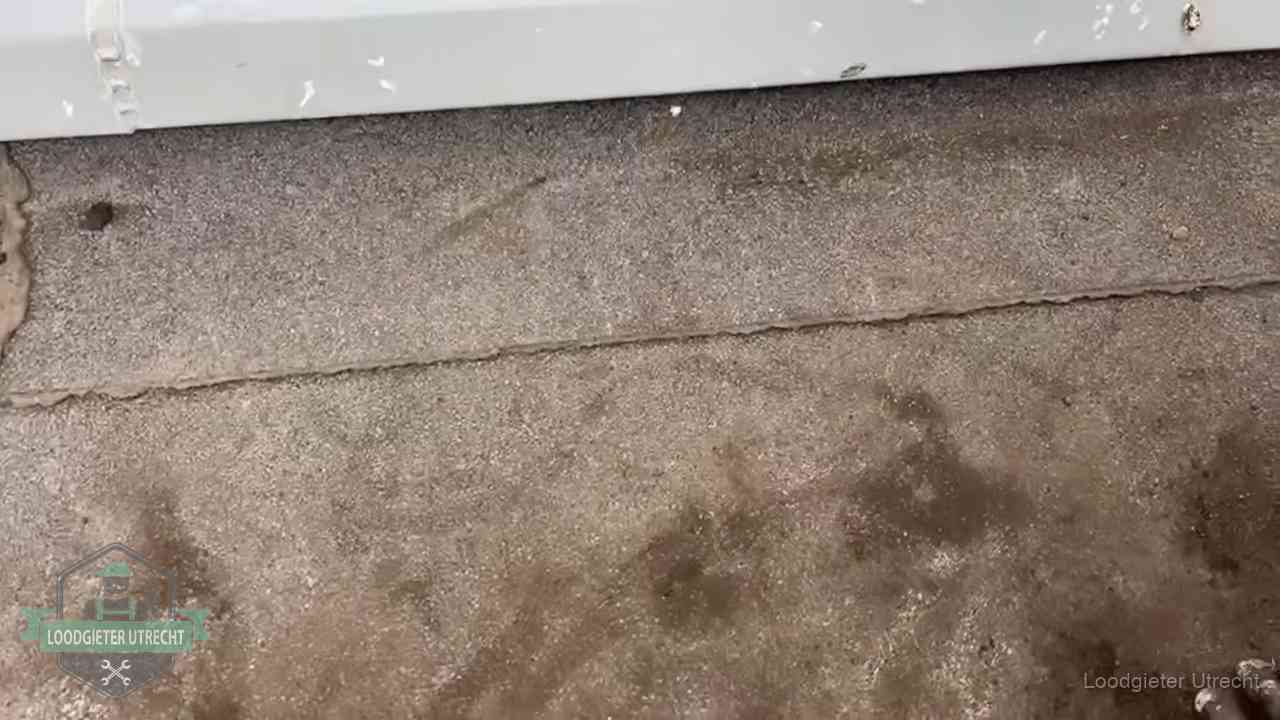 Vochtplekken bij de naad van een plat dak na aanhoudende regen in Utrecht