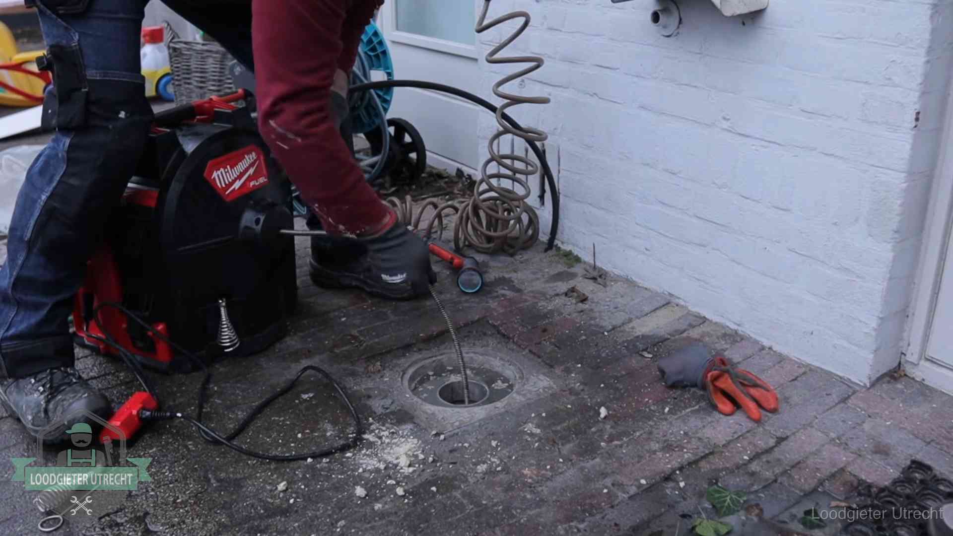 Spiraalmachine bij een ontstoppingsputje in de bestrating in Utrecht
