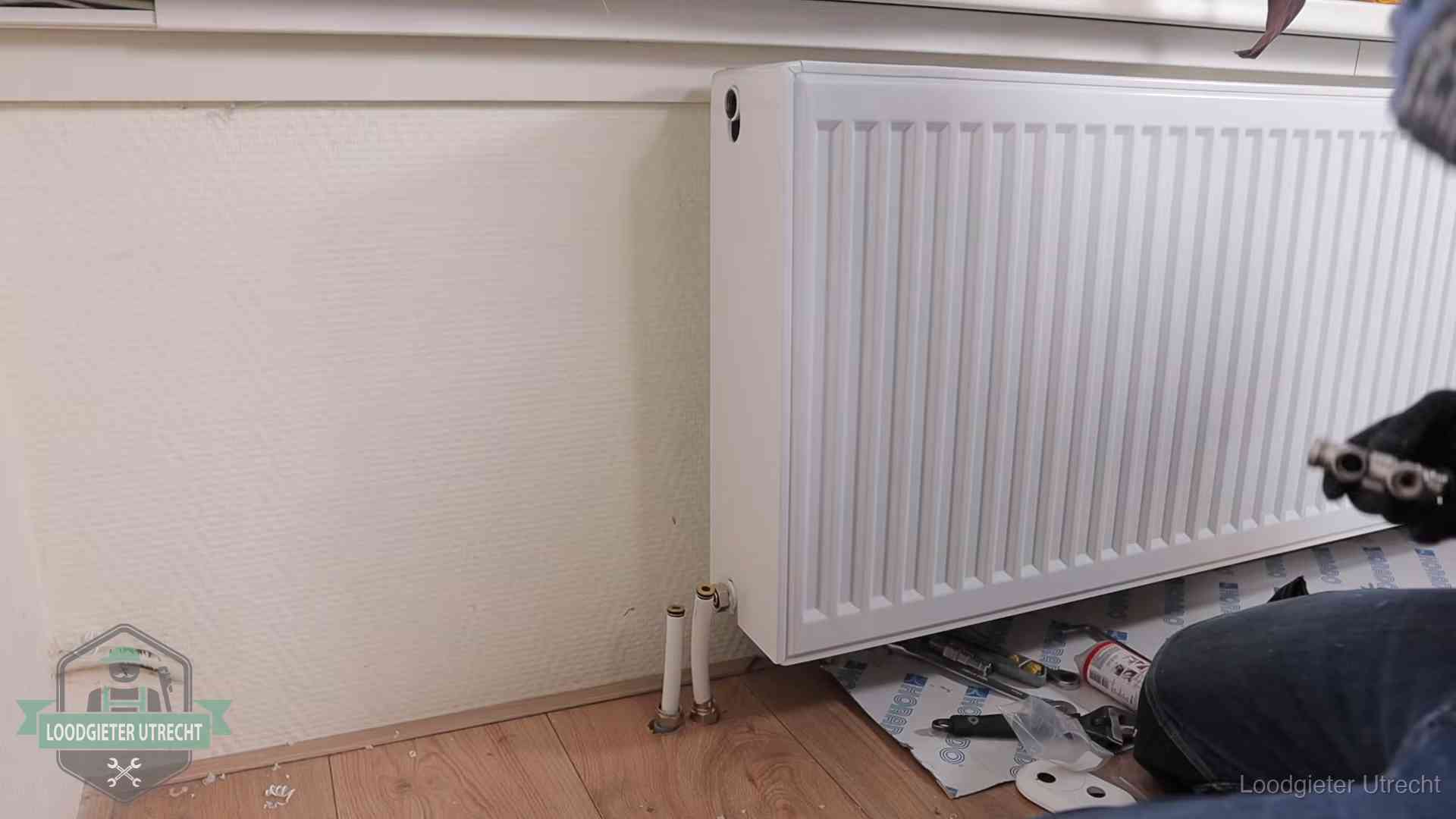 Verwarming per wijk in Utrecht Nieuw gemonteerde radiator in een woonkamer in Utrecht
