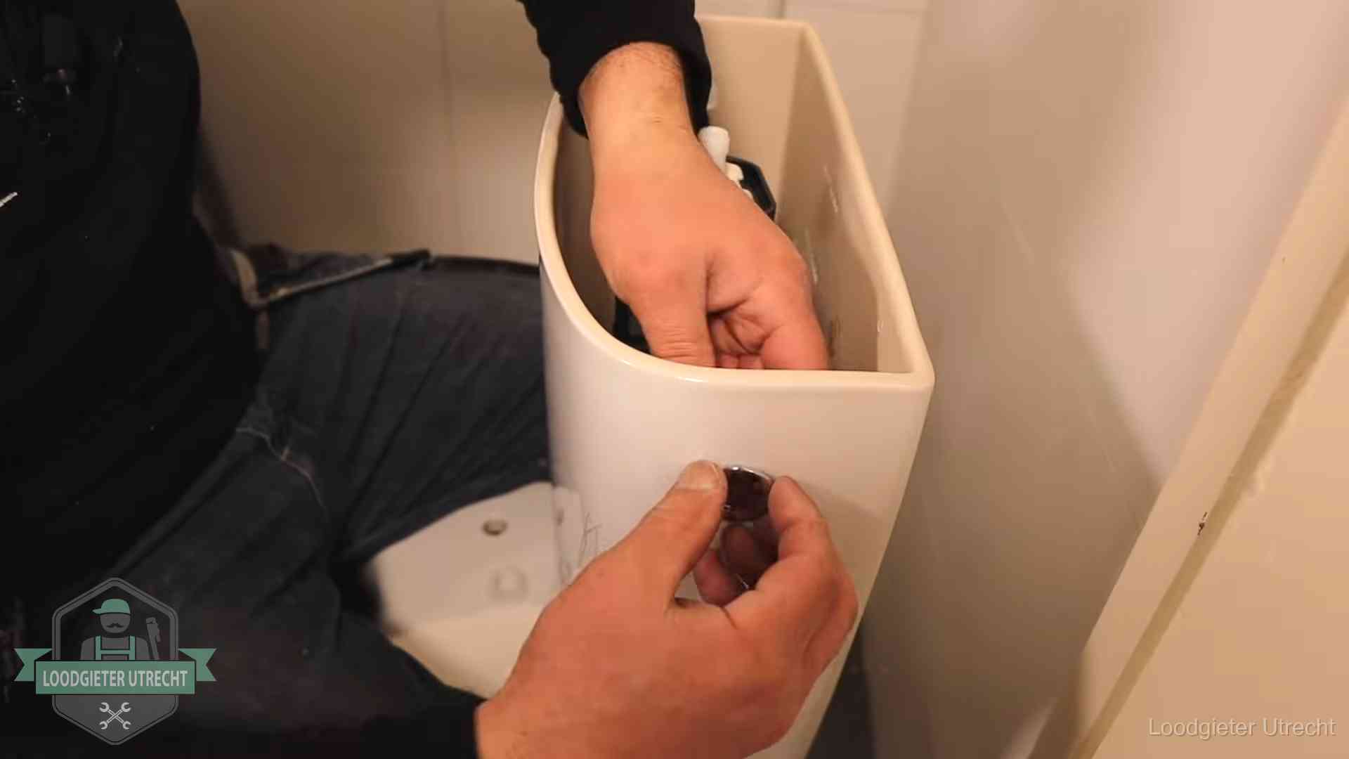 Je wc verstoppingsvrij houden in Utrecht Drukknop van een duoblok-stortbak wordt gemonteerd bij een toilet in Utrecht
