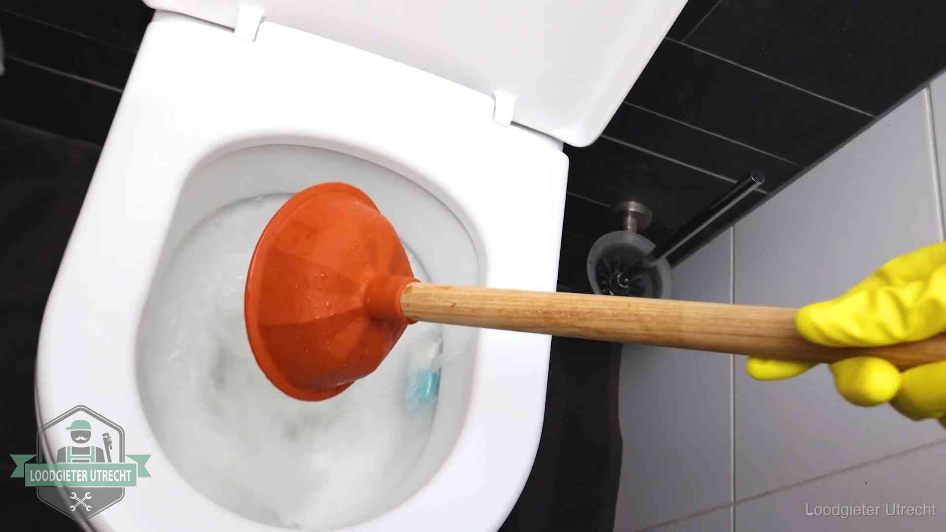 Wc ontstoppen met de plopper in Utrecht Plopper wordt in de wc-pot gedrukt bij het ontstoppen van een toilet in Utrecht