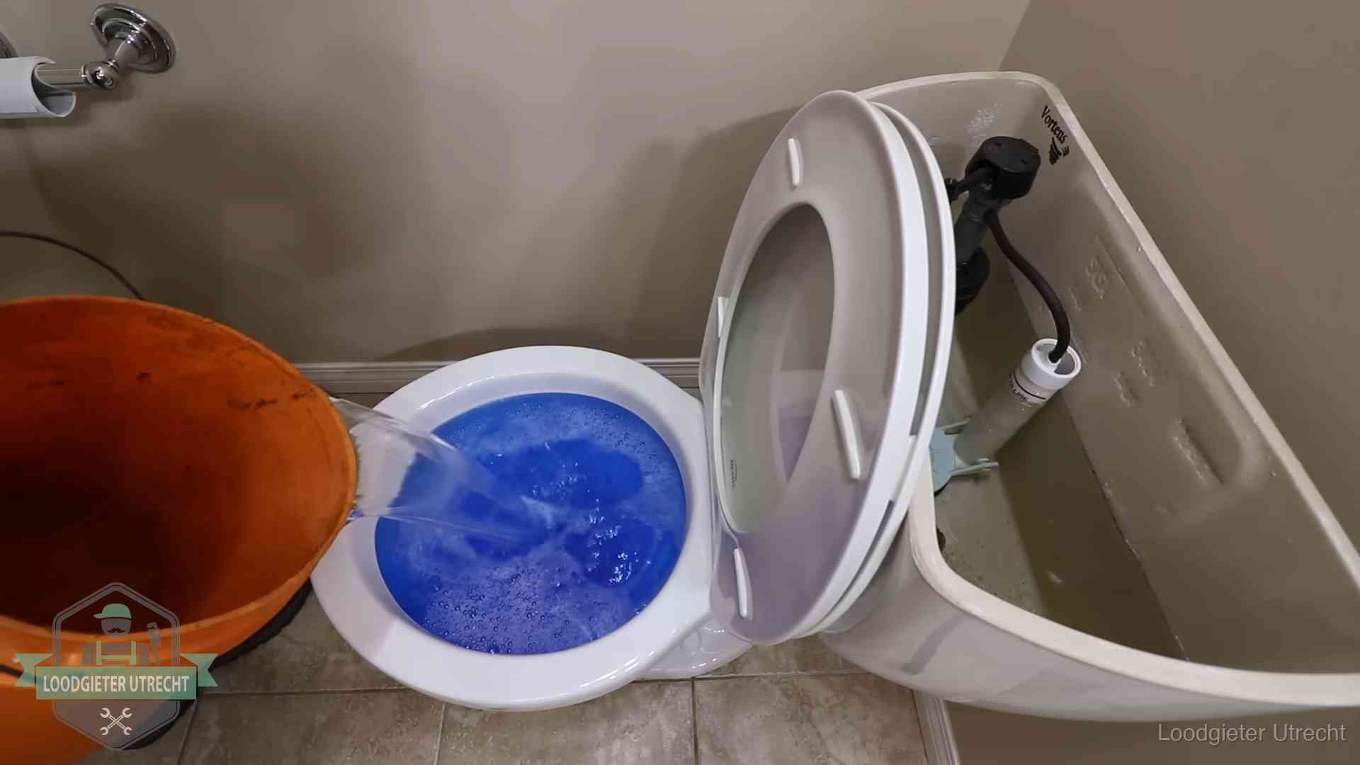 Water komt omhoog in de wc in Utrecht Water bij de wc-pot wordt met een emmer weggewerkt om schade te beperken in Utrecht